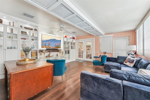 living room featuring ceiling fan, dark hardwood / wood-style flooring, built in features, and french doors