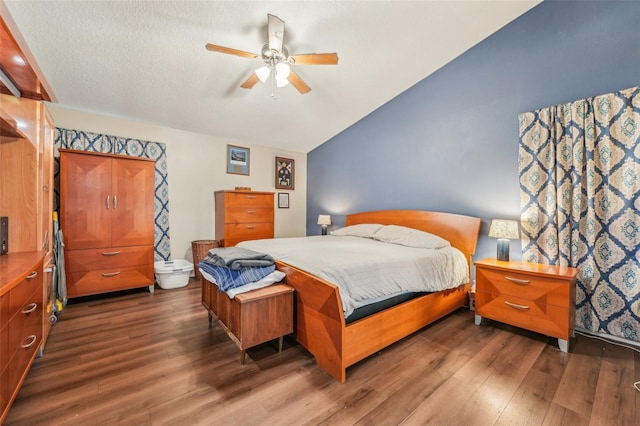 bedroom featuring dark hardwood / wood-style flooring, vaulted ceiling, and ceiling fan