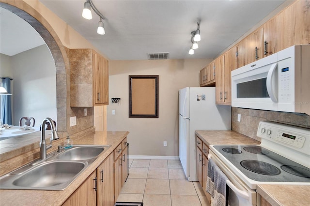 kitchen with decorative backsplash, light tile patterned floors, range with electric cooktop, and sink