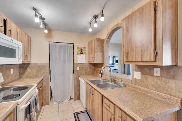 kitchen featuring light tile patterned flooring, white appliances, sink, and tasteful backsplash