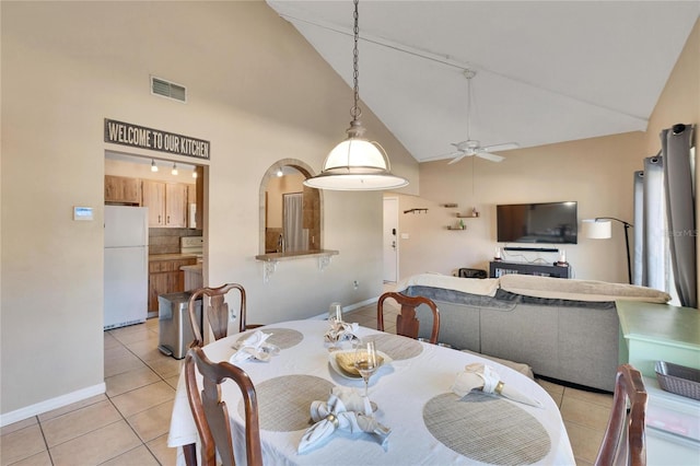 dining area with ceiling fan, light tile patterned floors, and high vaulted ceiling