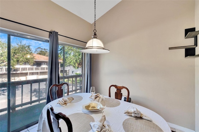 dining space with tile patterned flooring and lofted ceiling