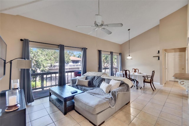 tiled living room featuring vaulted ceiling, ceiling fan, and a healthy amount of sunlight