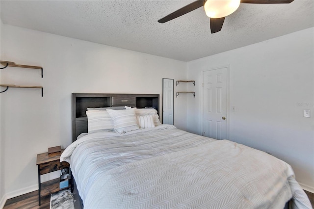 bedroom with hardwood / wood-style floors, ceiling fan, and a textured ceiling