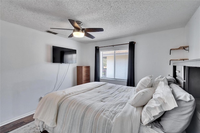 bedroom featuring wood-type flooring, a textured ceiling, and ceiling fan