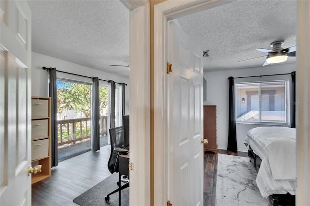 bedroom with access to exterior, a textured ceiling, light wood-type flooring, and ceiling fan