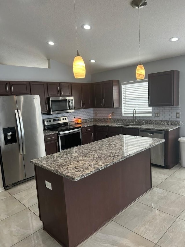 kitchen with a center island, sink, stainless steel appliances, and hanging light fixtures