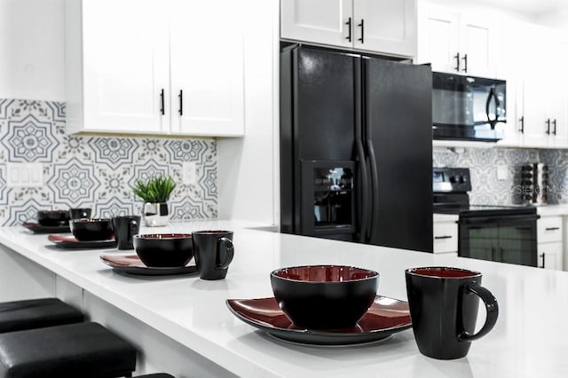 kitchen with decorative backsplash, white cabinets, and black appliances