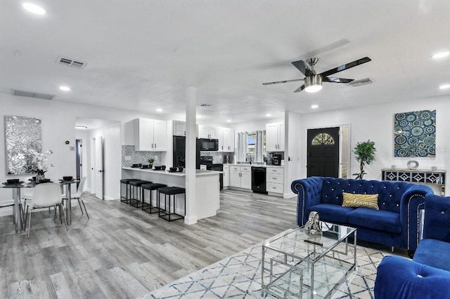 living room featuring light wood-type flooring and ceiling fan