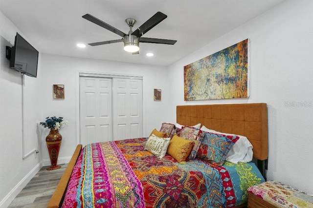 bedroom with hardwood / wood-style floors, a closet, and ceiling fan