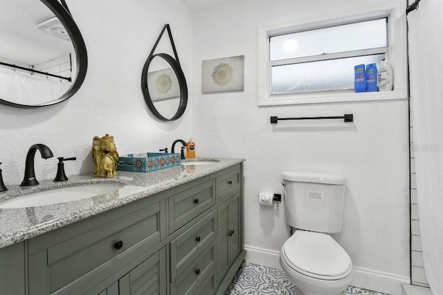 bathroom with tile patterned floors, vanity, toilet, and walk in shower