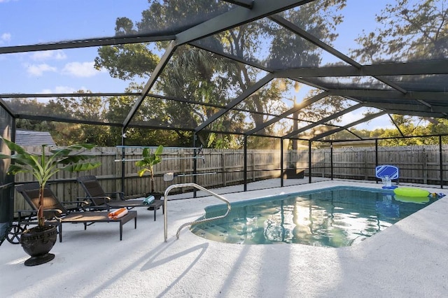 view of pool with glass enclosure and a patio area