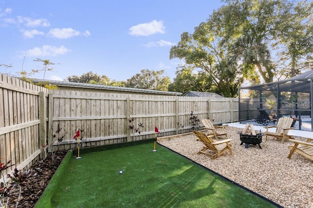 view of yard featuring glass enclosure and a fire pit