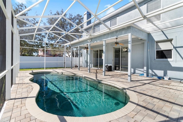 view of swimming pool with ceiling fan, a patio, and a lanai