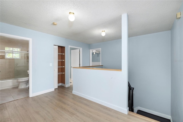 1600 Gray Bark Dr, Oldsmar, FL 34677 - interior space featuring baseboards, a baseboard radiator, a textured ceiling, and wood finished floors