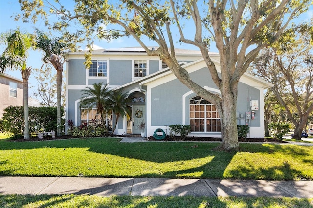1600 Gray Bark Dr, Oldsmar, FL 34677 - view of front of home with a front lawn, roof mounted solar panels, and stucco siding