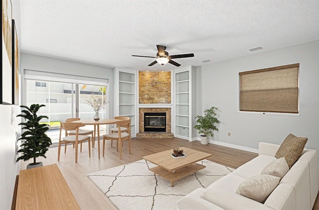 1600 Gray Bark Dr, Oldsmar, FL 34677 - living room with ceiling fan, a brick fireplace, a textured ceiling, built in features, and baseboards