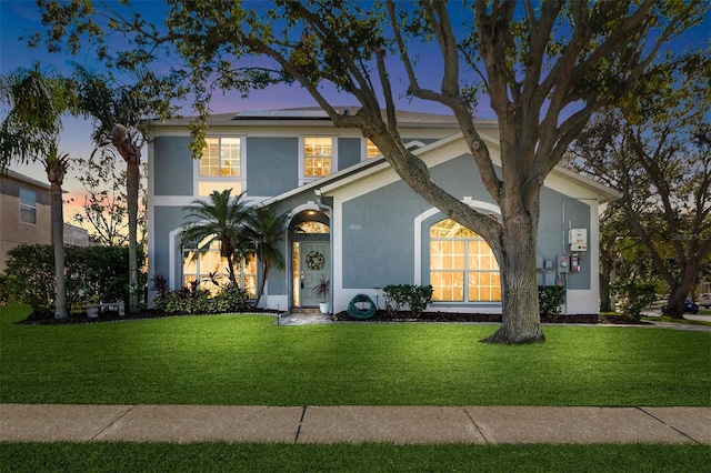 1600 Gray Bark Dr, Oldsmar, FL 34677 - view of front facade with a front lawn, roof mounted solar panels, and stucco siding