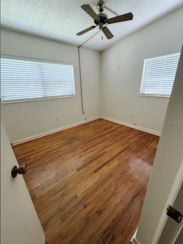 empty room with ceiling fan and hardwood / wood-style floors