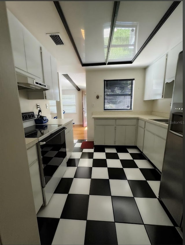 kitchen with stainless steel fridge with ice dispenser, a wealth of natural light, white cabinetry, and white electric range oven