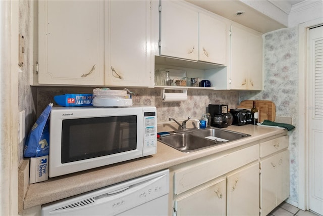 kitchen featuring white cabinetry, light tile patterned flooring, white appliances, and sink