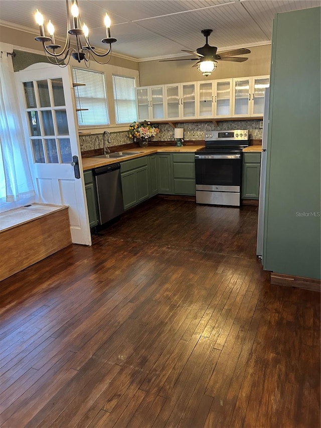 kitchen with backsplash, dark wood-type flooring, green cabinets, sink, and appliances with stainless steel finishes