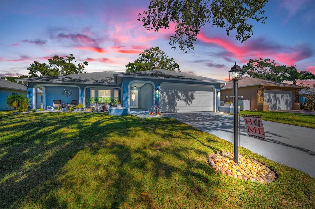 view of front of property featuring a garage and a lawn