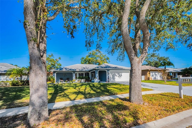 ranch-style home featuring a front lawn and a garage