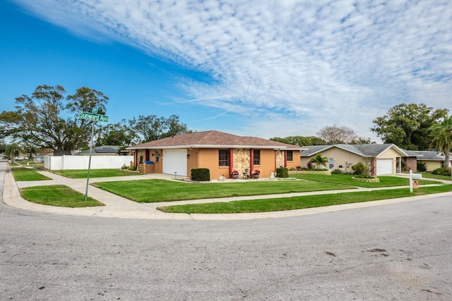 ranch-style home with a garage and a front lawn