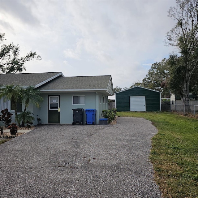 view of front of property with a garage, an outbuilding, and a front yard