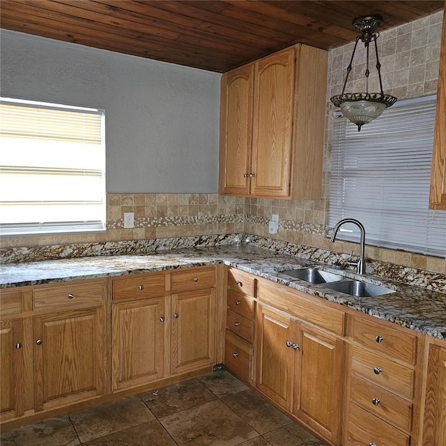 kitchen with backsplash, sink, wooden ceiling, and stone countertops