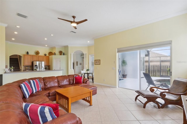 living room with ceiling fan, light tile patterned flooring, and crown molding