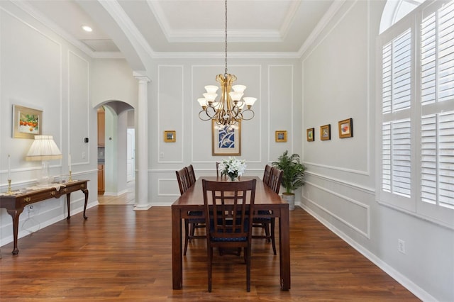 dining space with a raised ceiling, crown molding, dark hardwood / wood-style floors, and a notable chandelier