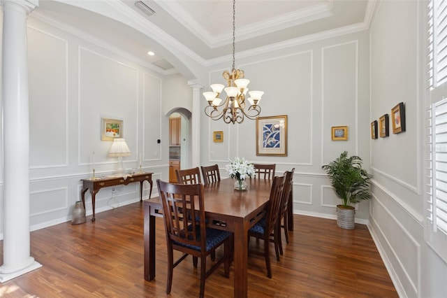 dining space featuring a tray ceiling, dark hardwood / wood-style flooring, a chandelier, and ornamental molding