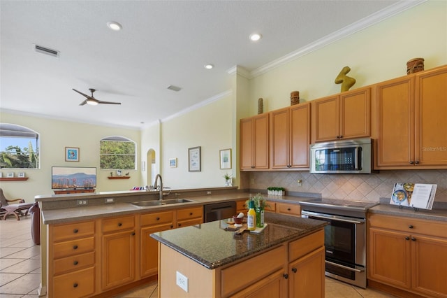 kitchen featuring a kitchen island, sink, stainless steel appliances, and light tile patterned flooring