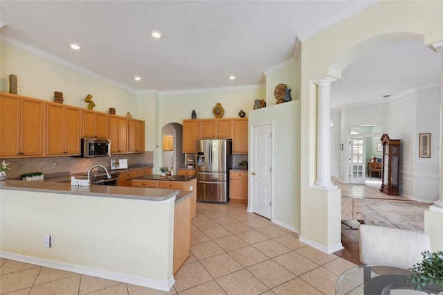 kitchen featuring ornate columns, crown molding, decorative backsplash, light tile patterned floors, and appliances with stainless steel finishes