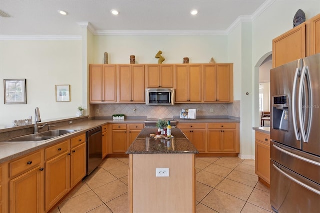 kitchen featuring a center island, sink, stainless steel appliances, light tile patterned floors, and ornamental molding