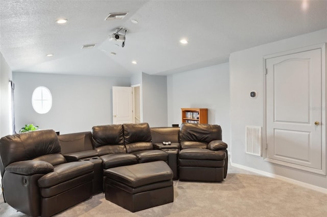 carpeted cinema room with a textured ceiling and vaulted ceiling