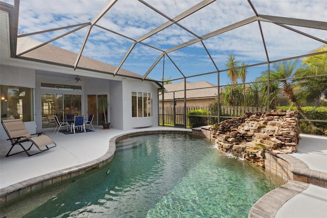 view of pool with ceiling fan, a patio area, and glass enclosure