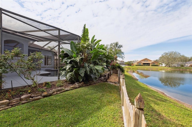 view of yard with a lanai and a water view