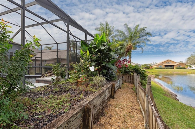 view of yard with a lanai and a water view