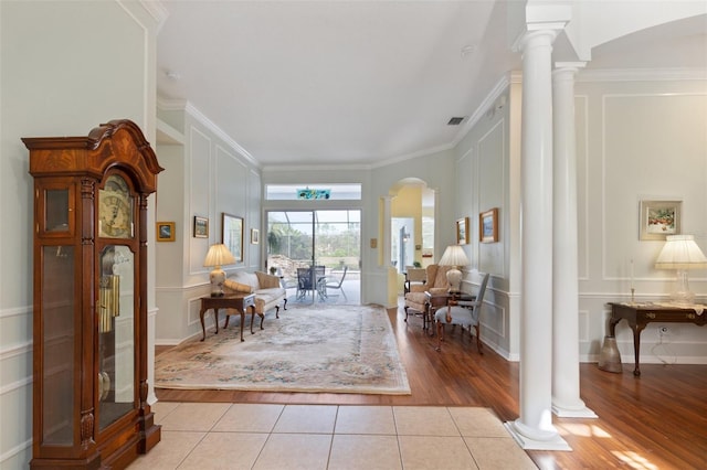 sitting room with light tile patterned floors, decorative columns, and crown molding