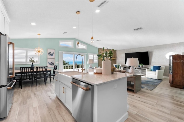 kitchen featuring white cabinetry, stainless steel appliances, a center island, and pendant lighting