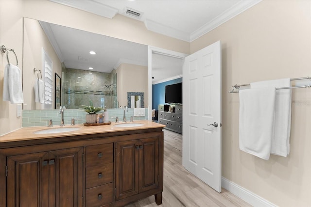 bathroom with hardwood / wood-style floors, backsplash, ornamental molding, vanity, and a shower with door