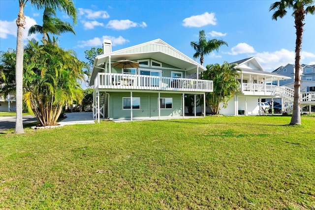 rear view of property featuring a lawn and a patio