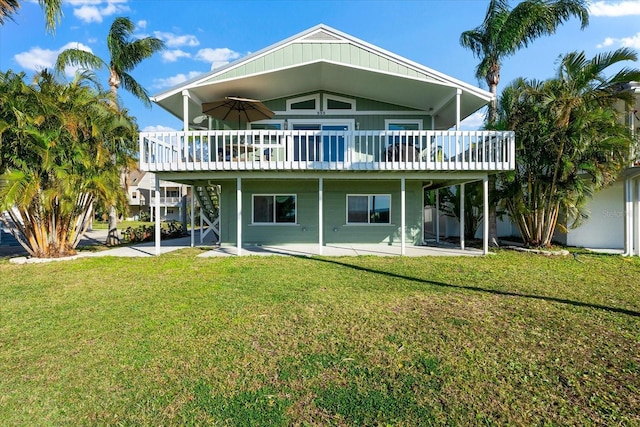 rear view of property with a wooden deck, ceiling fan, a patio area, and a lawn