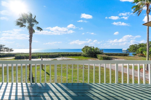 deck featuring a water view and a lawn