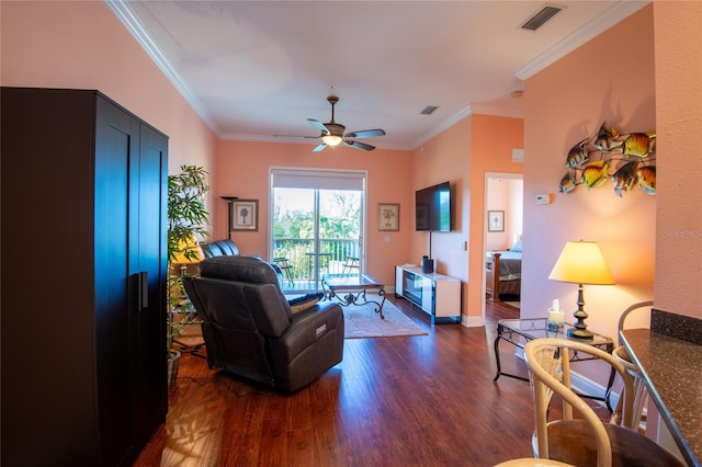 living room with ceiling fan, crown molding, and dark wood-type flooring