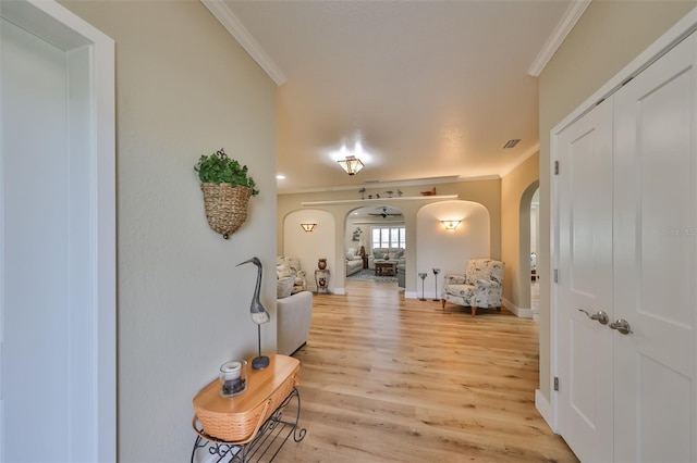 corridor with light wood-type flooring and ornamental molding