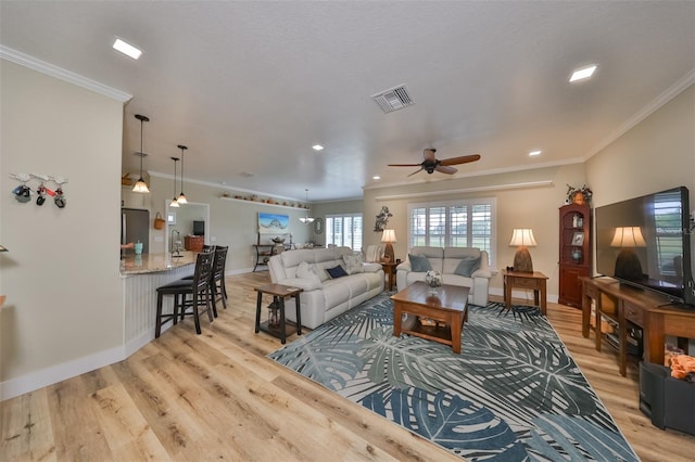 living room featuring light hardwood / wood-style floors, ceiling fan, and ornamental molding